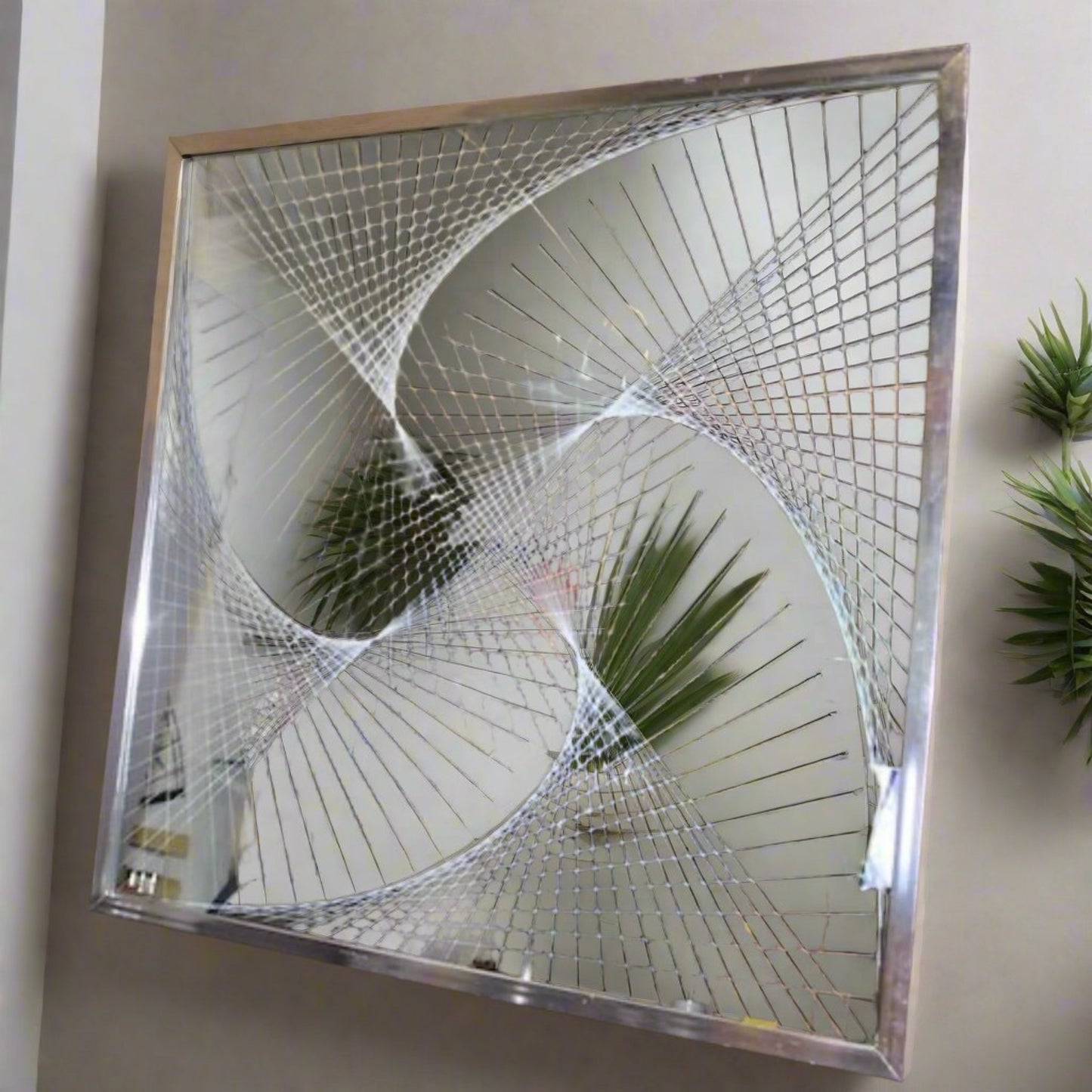 Chrome framed mirror with a spiral design on glass.