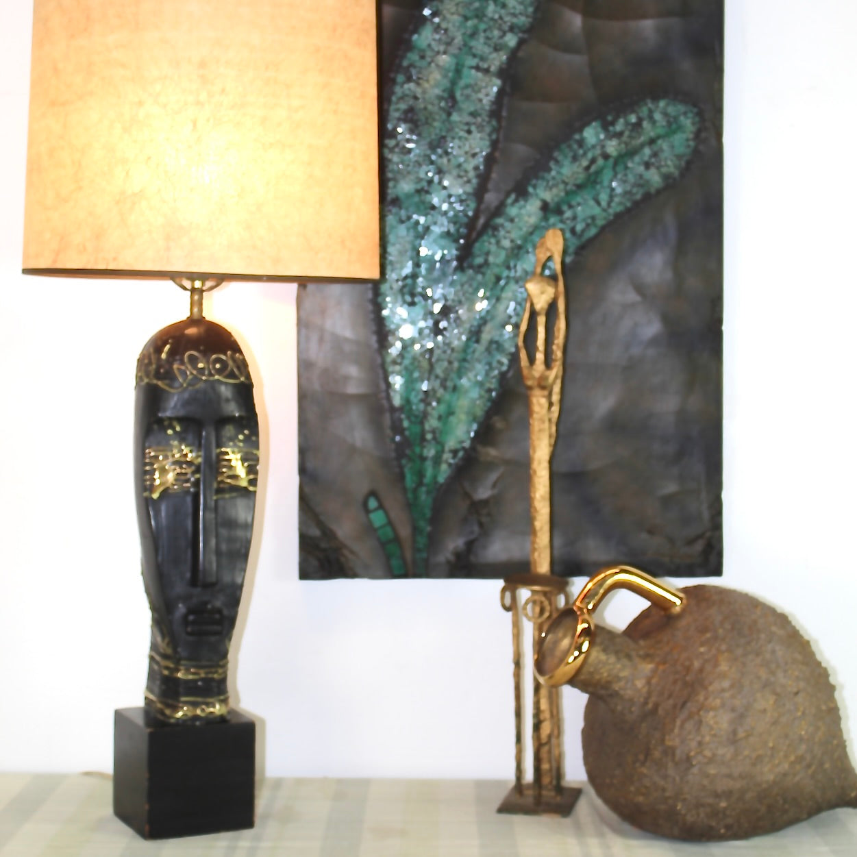 Tribal Head Bust Table Lamp with amphora vase and golden African female statue and a glass tile painting.